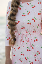 Model wearing Nuggles® Nola Sport Swim Dress in Cherry Soda Shop