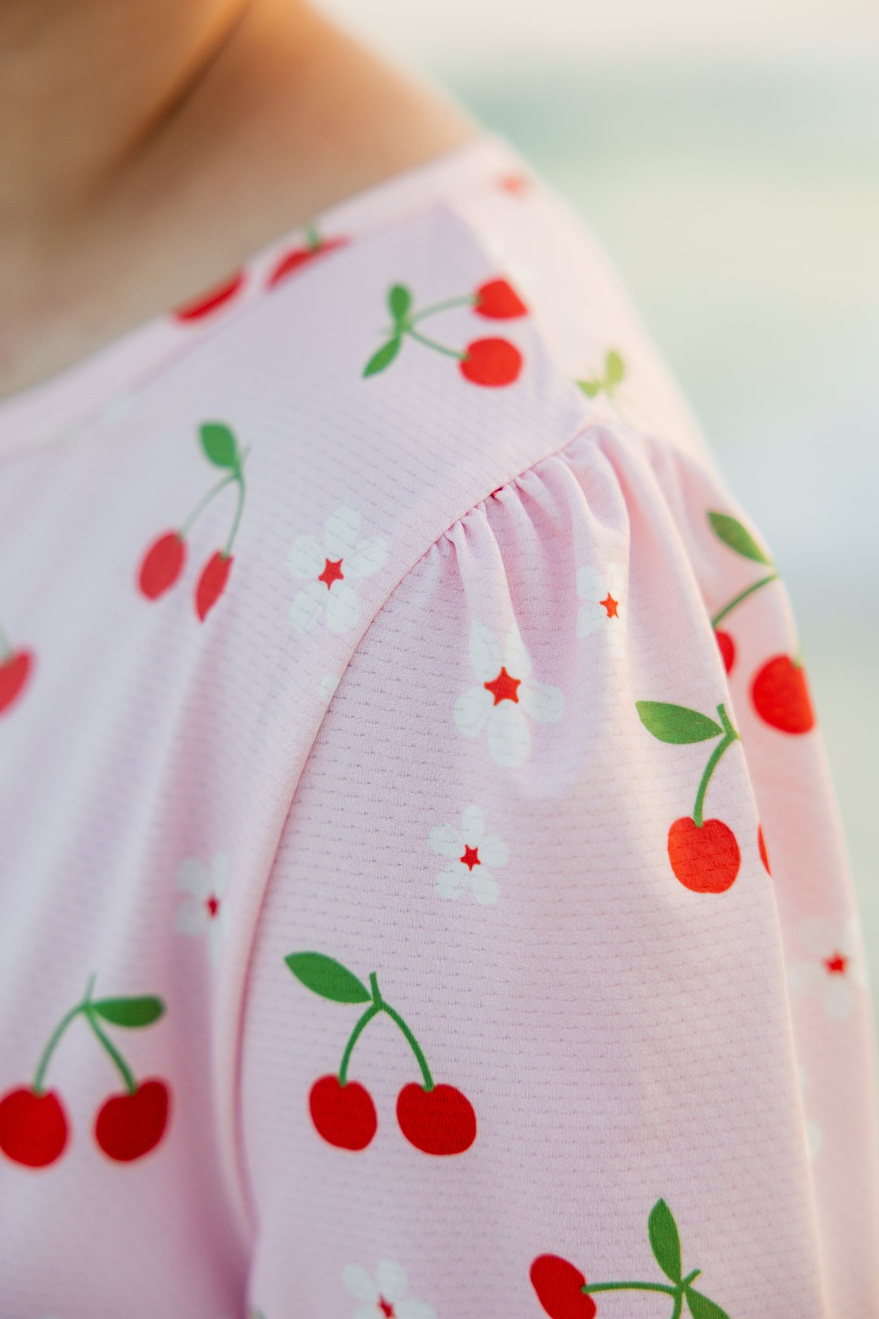 Model wearing Nuggles® Nola Sport Swim Dress in Cherry Soda Shop