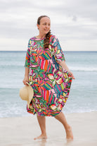 Model wearing Nuggles® Carlie Swim Dress in Aloha Bloom