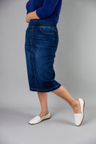 Nuggles® denim midi skirt with soft stretch fabric, wide elastic waistband, modest length, and functional pockets. Available in 27", 31", and 34" lengths.