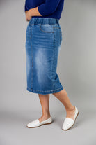 Nuggles® denim midi skirt with soft stretch fabric, wide elastic waistband, modest length, and functional pockets. Available in 27", 31", and 34" lengths.