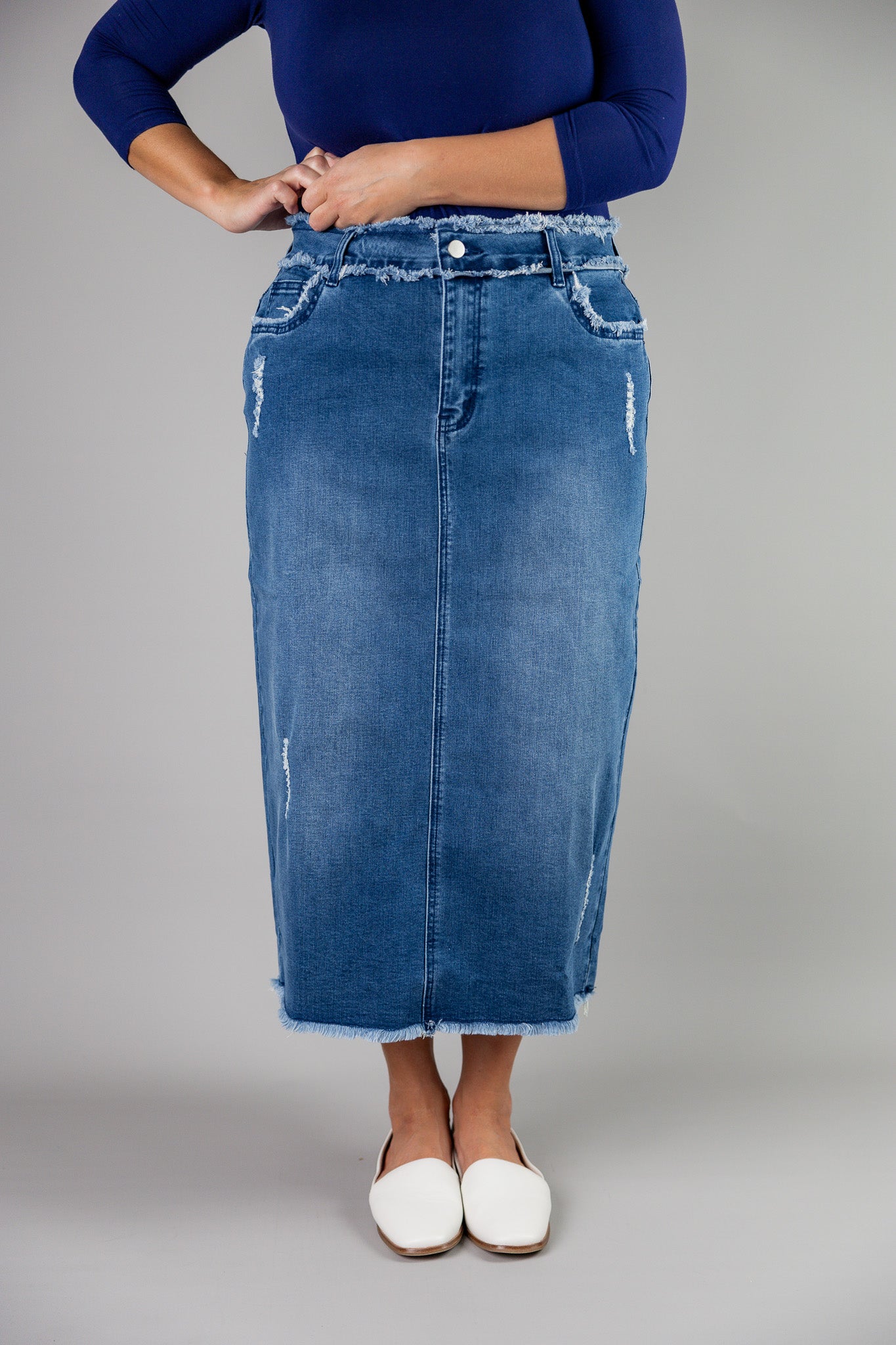 Nuggles® denim midi skirt with soft stretch fabric, wide elastic waistband, modest length, and functional pockets. Available in 27", 31", and 34" lengths.