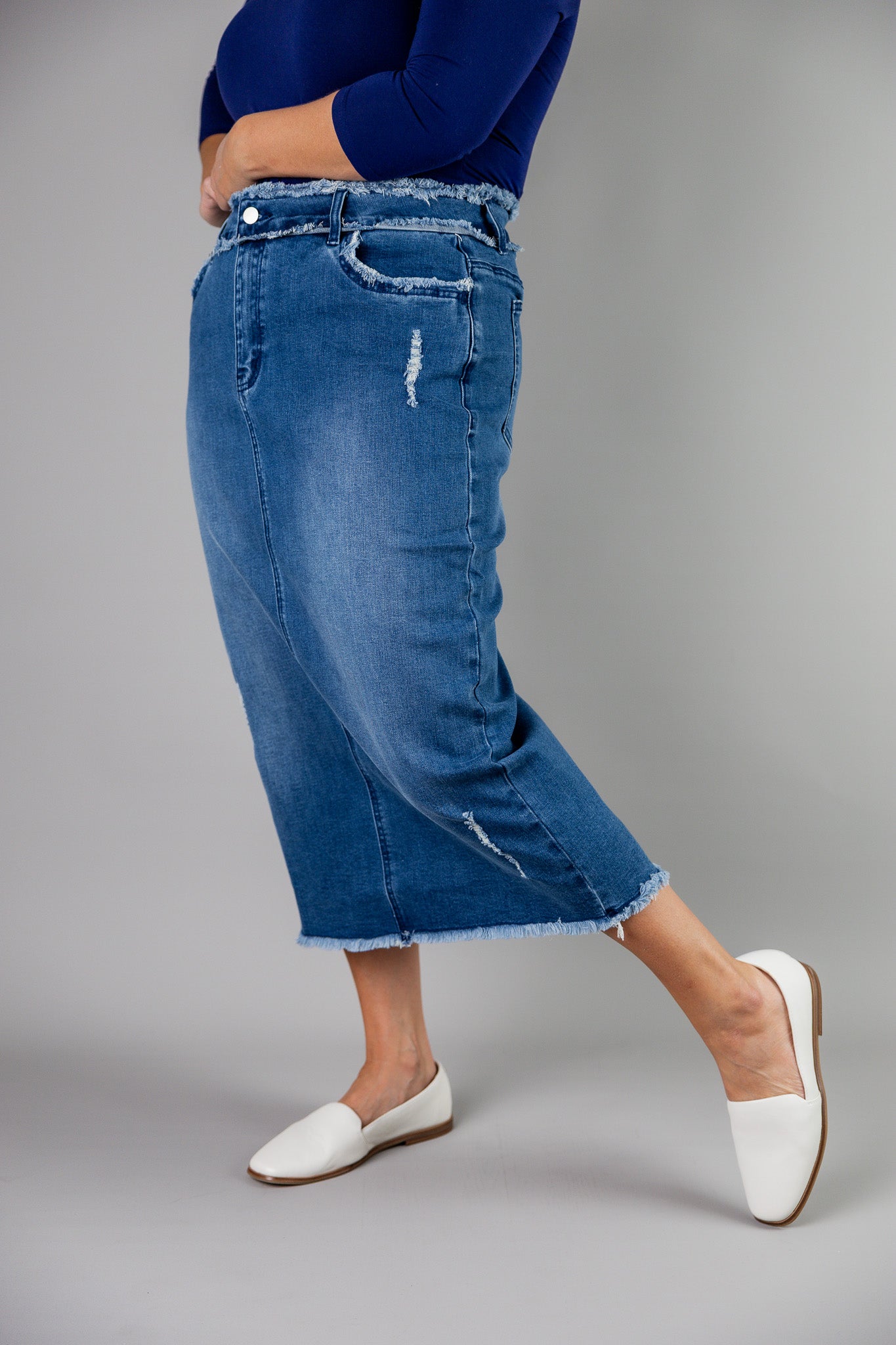 Nuggles® denim midi skirt with soft stretch fabric, wide elastic waistband, modest length, and functional pockets. Available in 27", 31", and 34" lengths.