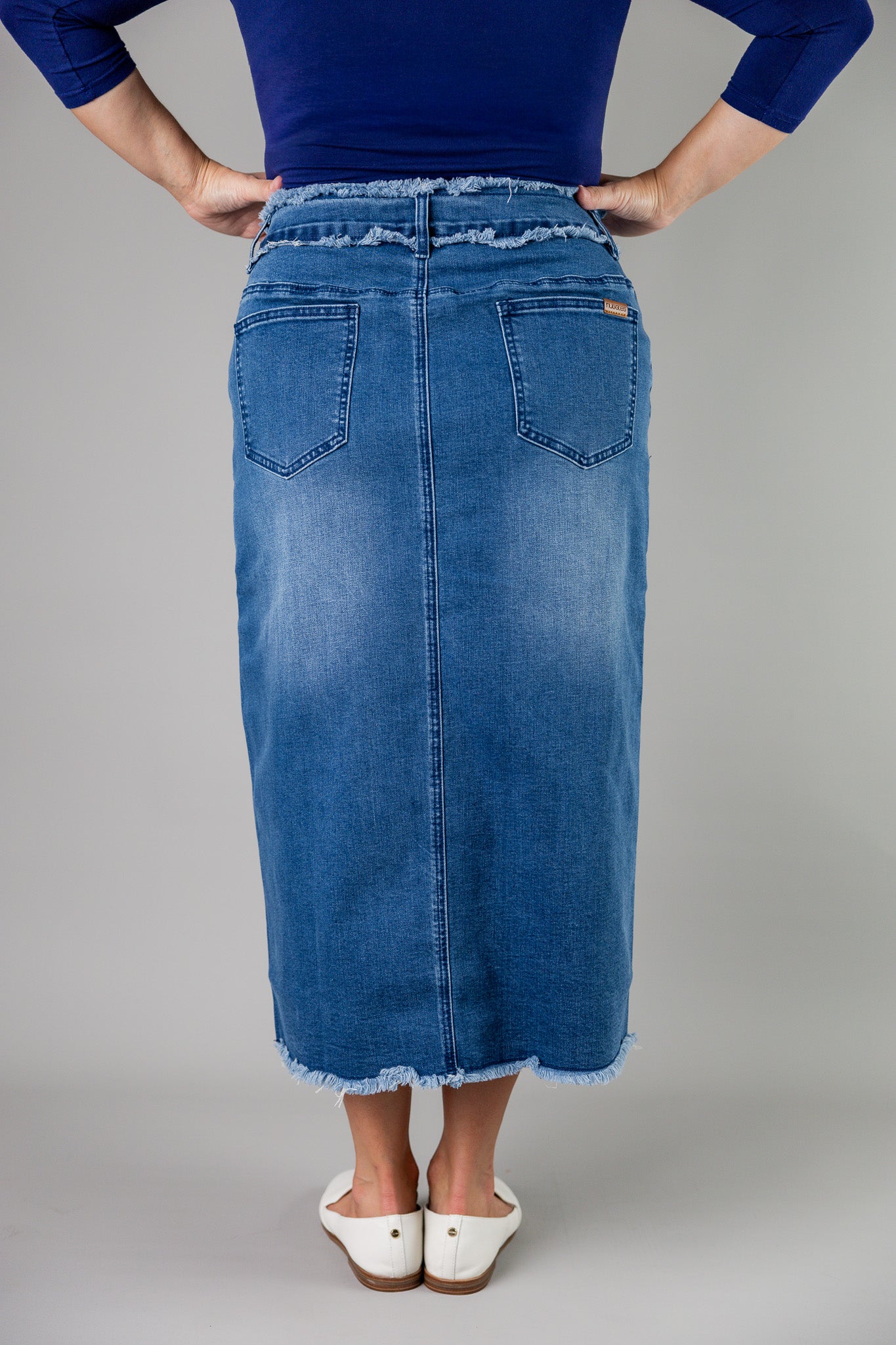 Nuggles® denim midi skirt with soft stretch fabric, wide elastic waistband, modest length, and functional pockets. Available in 27", 31", and 34" lengths.