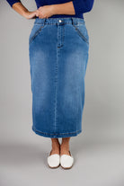 Nuggles® denim midi skirt with soft stretch fabric, wide elastic waistband, modest length, and functional pockets. Available in 27", 31", and 34" lengths.