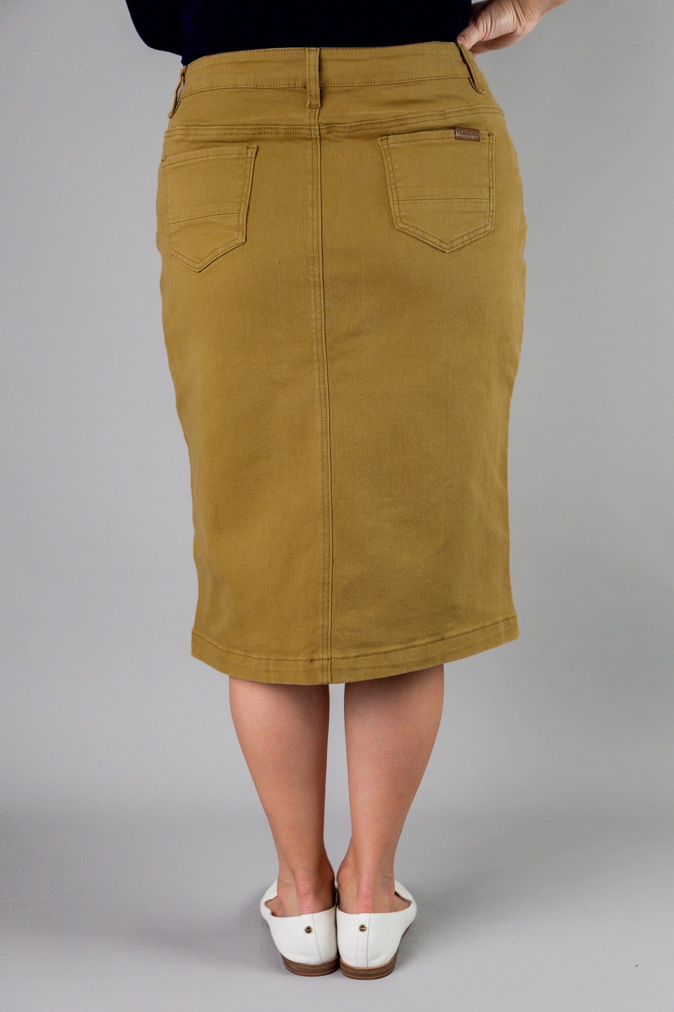 Nuggles® denim midi skirt with soft stretch fabric, wide elastic waistband, modest length, and functional pockets. Available in 27", 31", and 34" lengths.