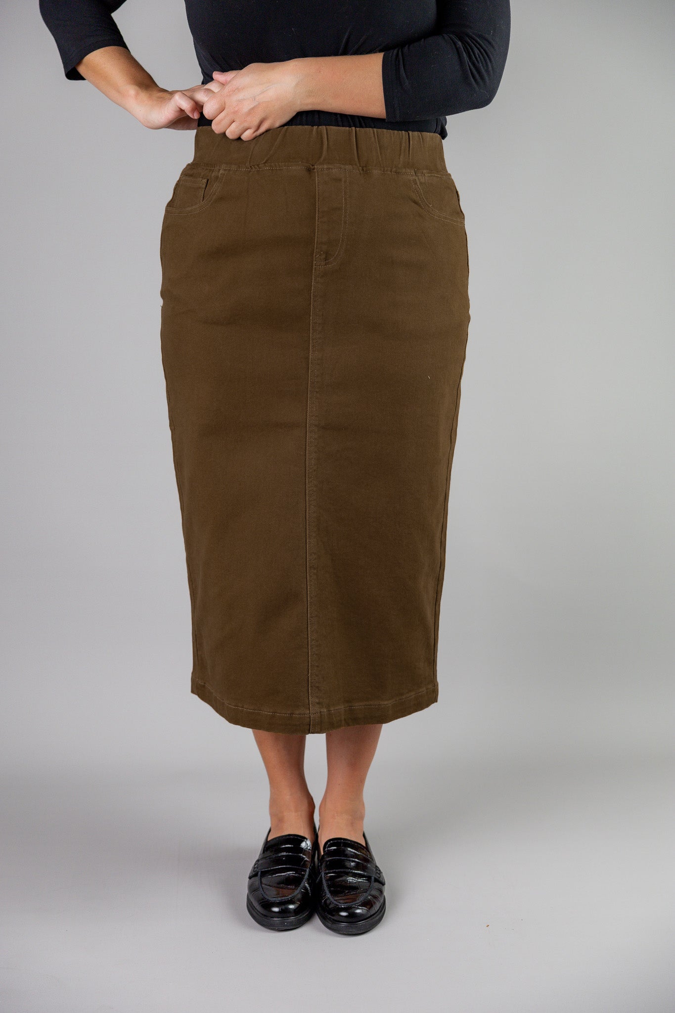 Nuggles® denim midi skirt with soft stretch fabric, wide elastic waistband, modest length, and functional pockets. Available in 27", 31", and 34" lengths.