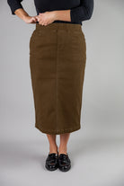 Nuggles® denim midi skirt with soft stretch fabric, wide elastic waistband, modest length, and functional pockets. Available in 27", 31", and 34" lengths.