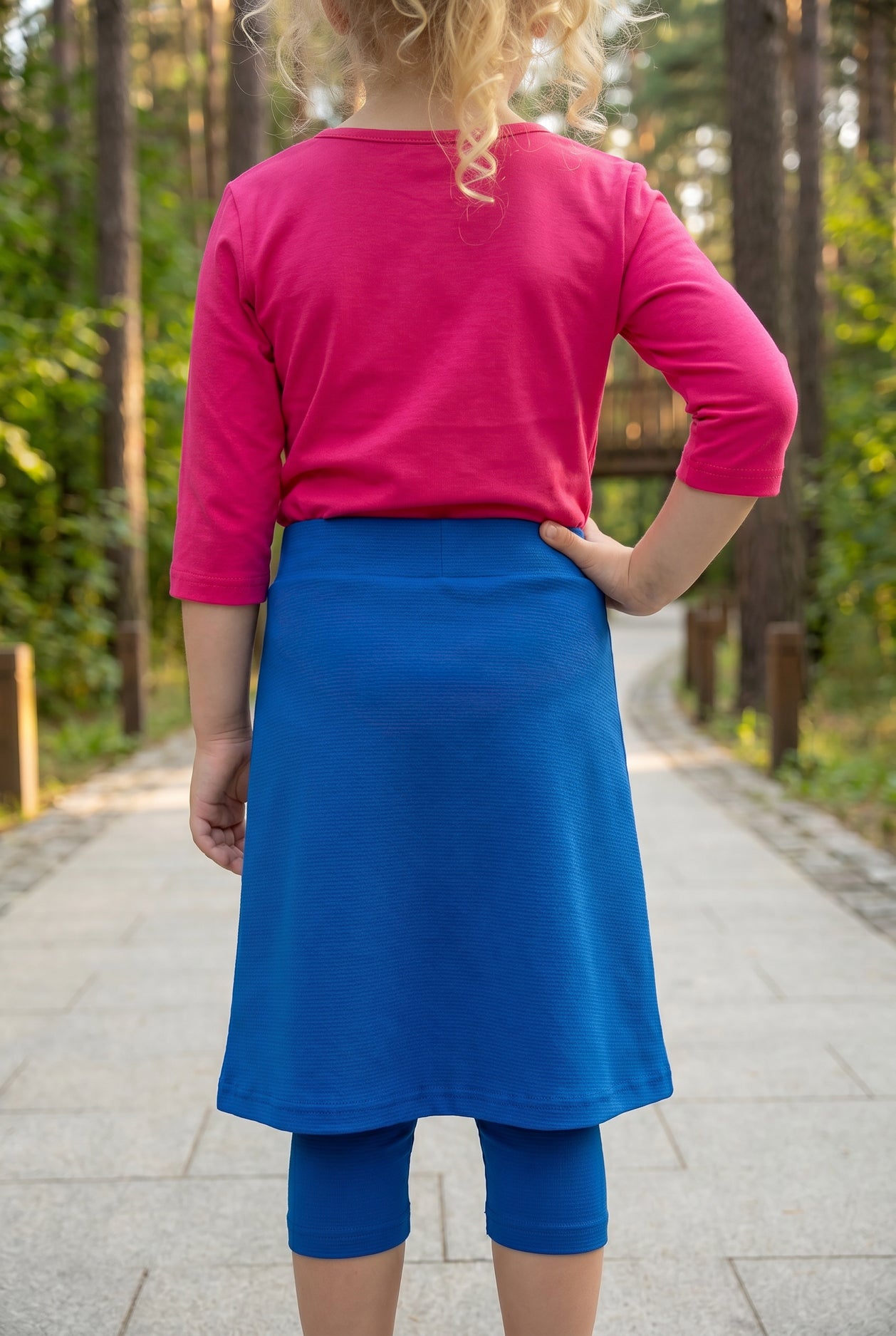 Model wearing Nuggles® Girls All-Sport Skirt in Lapiz Blue