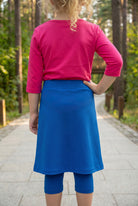Model wearing Nuggles® Girls All-Sport Skirt in Lapiz Blue