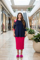 Woman modeling a navy floral-sleeve top in a mall.