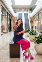 Woman modeling a navy floral-sleeve top in a mall.
