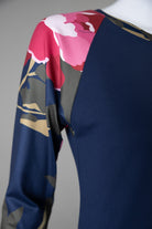 A close up picture of a navy top with pink flowers on the sleeves.