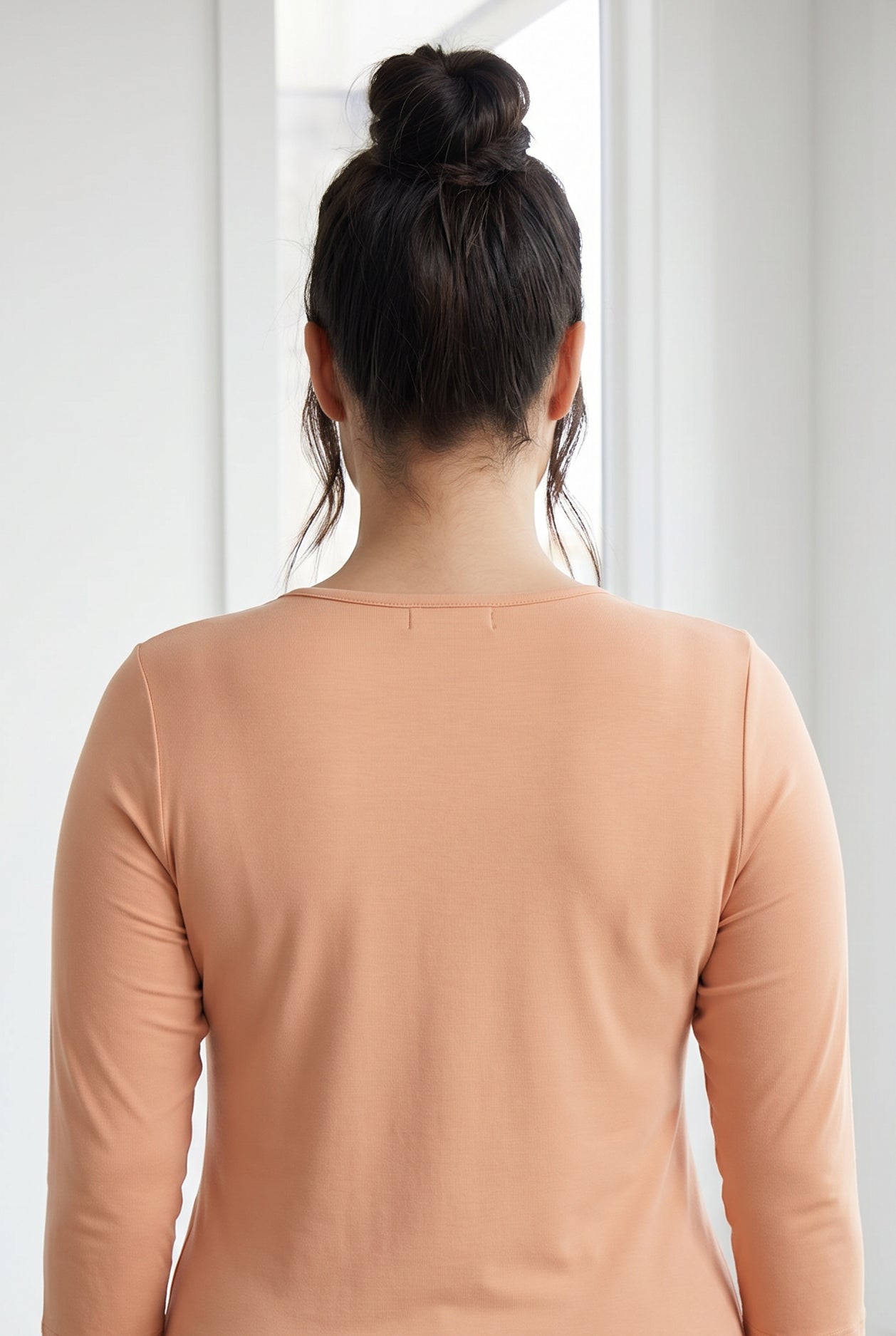Model wearing Nuggles® 3/4 Essential Tee in Peach