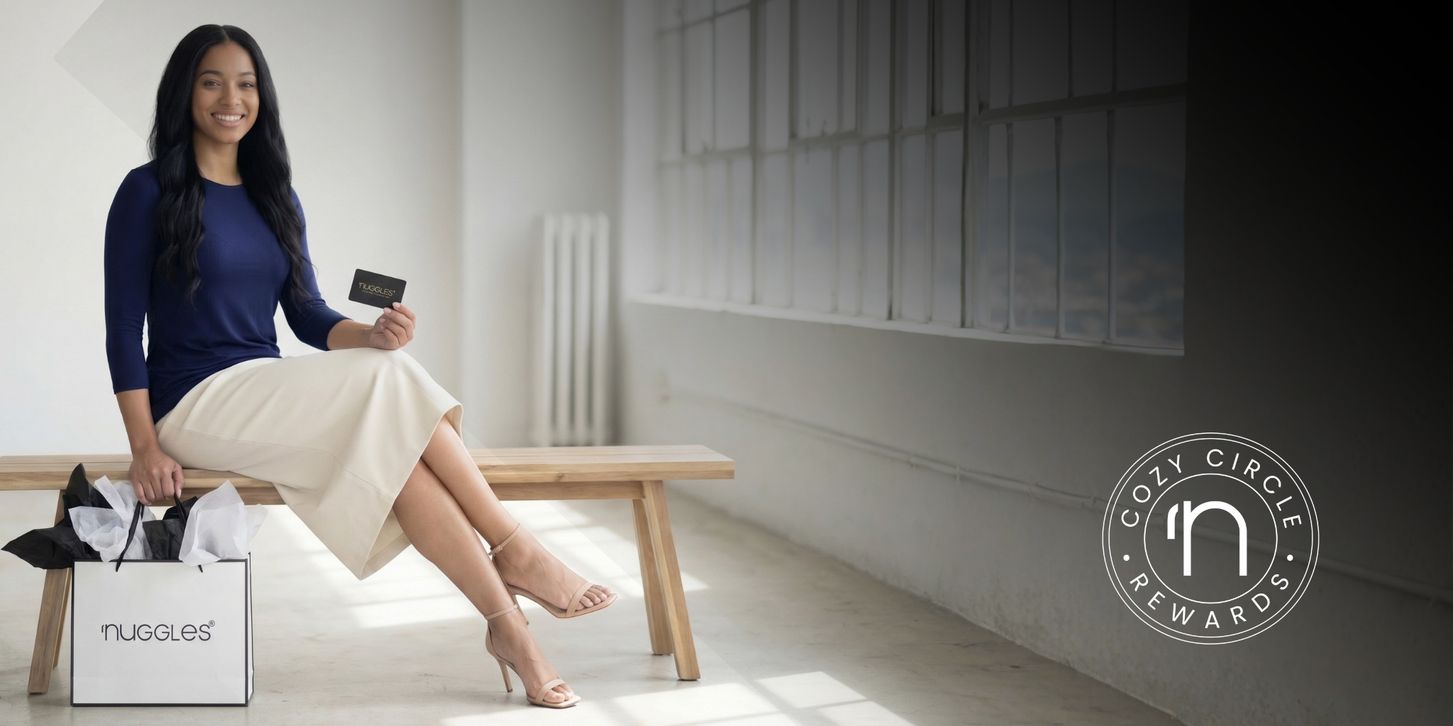 A picture of a women sitting on a wooden bench holding a nuggles gift card and a gift bag.