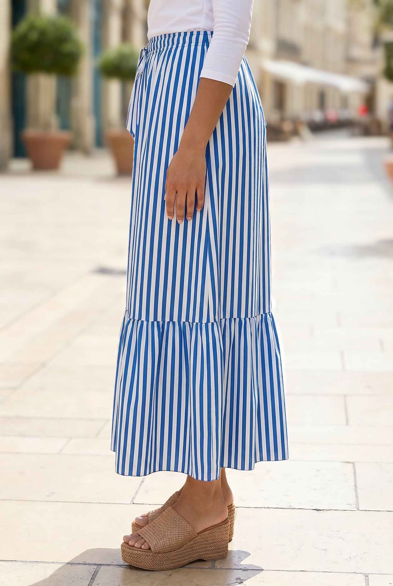 A women wearing a veritcal blue and white striped maxi skirt.