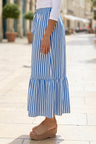 A women wearing a veritcal blue and white striped maxi skirt.