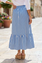 A women wearing a veritcal blue and white striped maxi skirt.