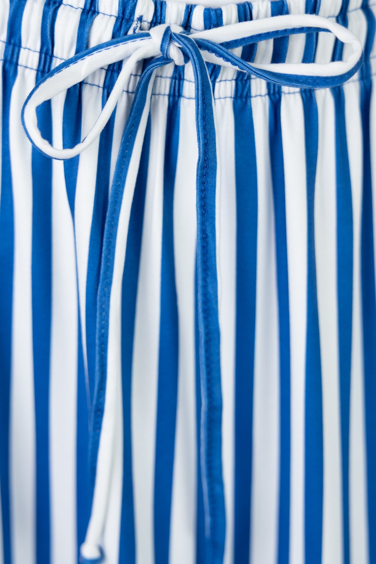 Close-up of blue and white striped skirt with a tie waist.