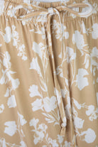 Closeup Shot of the tie of the waistband on a yellow floral skirt.