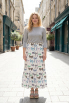 Person wearing a maxi skirt with a bow pattern. 