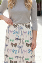 Person wearing a maxi skirt with a bow pattern. 
