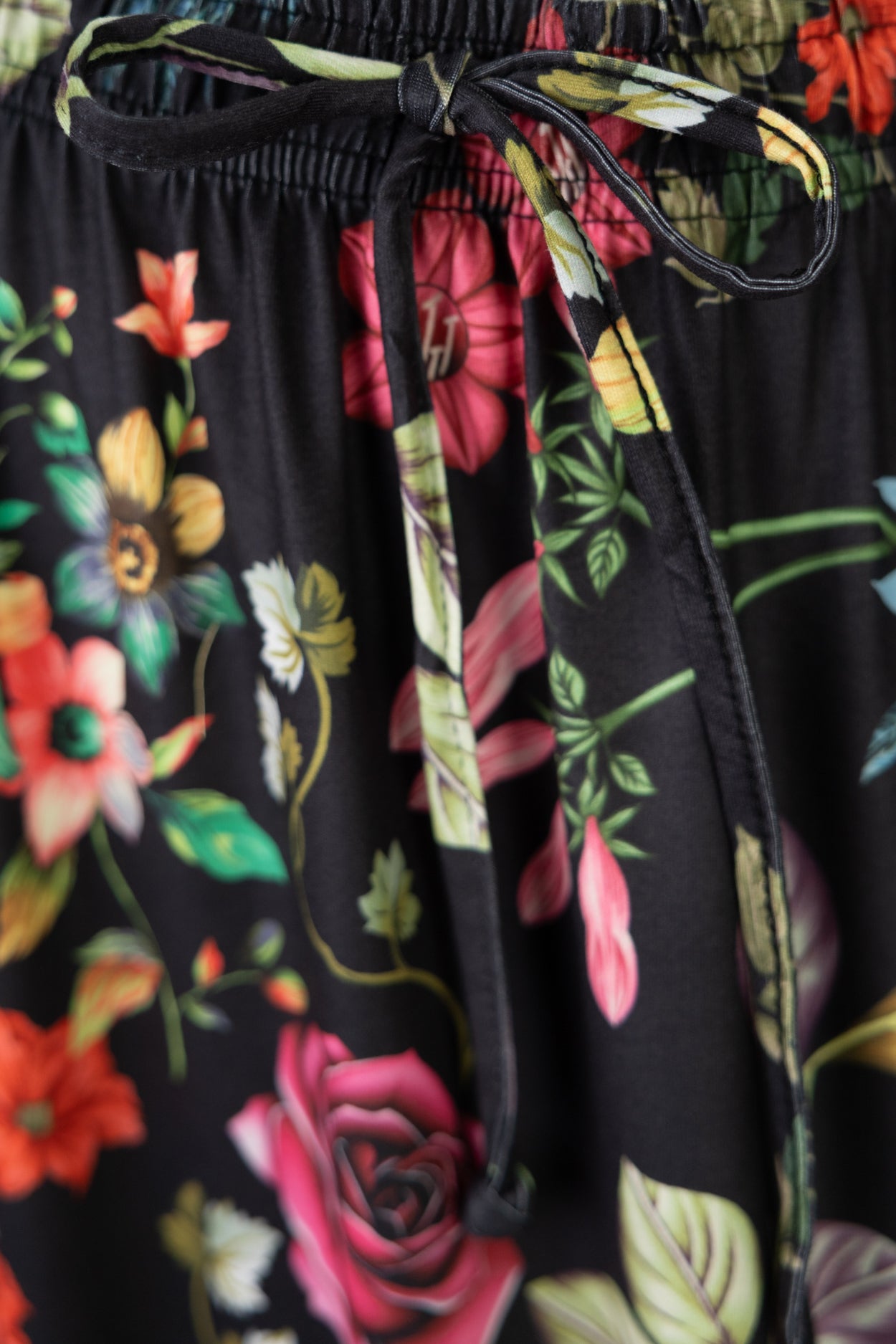 Floral-patterned fabric with a black drawstring on a dark background