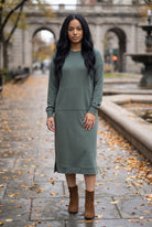 Nuggles® Oakley Hoodie Dress in Steel Blue, full-length front view on a wet stone walkway with brown ankle boots