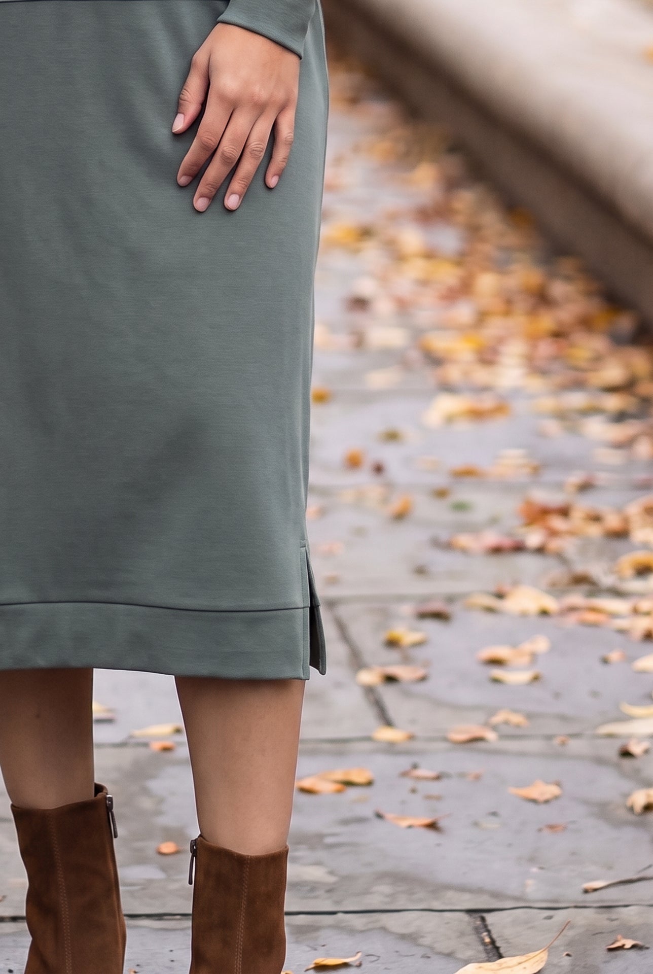 Nuggles® Oakley Hoodie Dress in Steel Blue, close-up of the banded hem and side slit with a hand on the hip