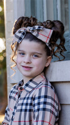 Model wearing the Nuggles® Headband in Sand Plaid