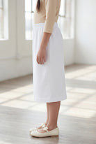 Model wearing Nuggles®  Girls Classic Skirt in White