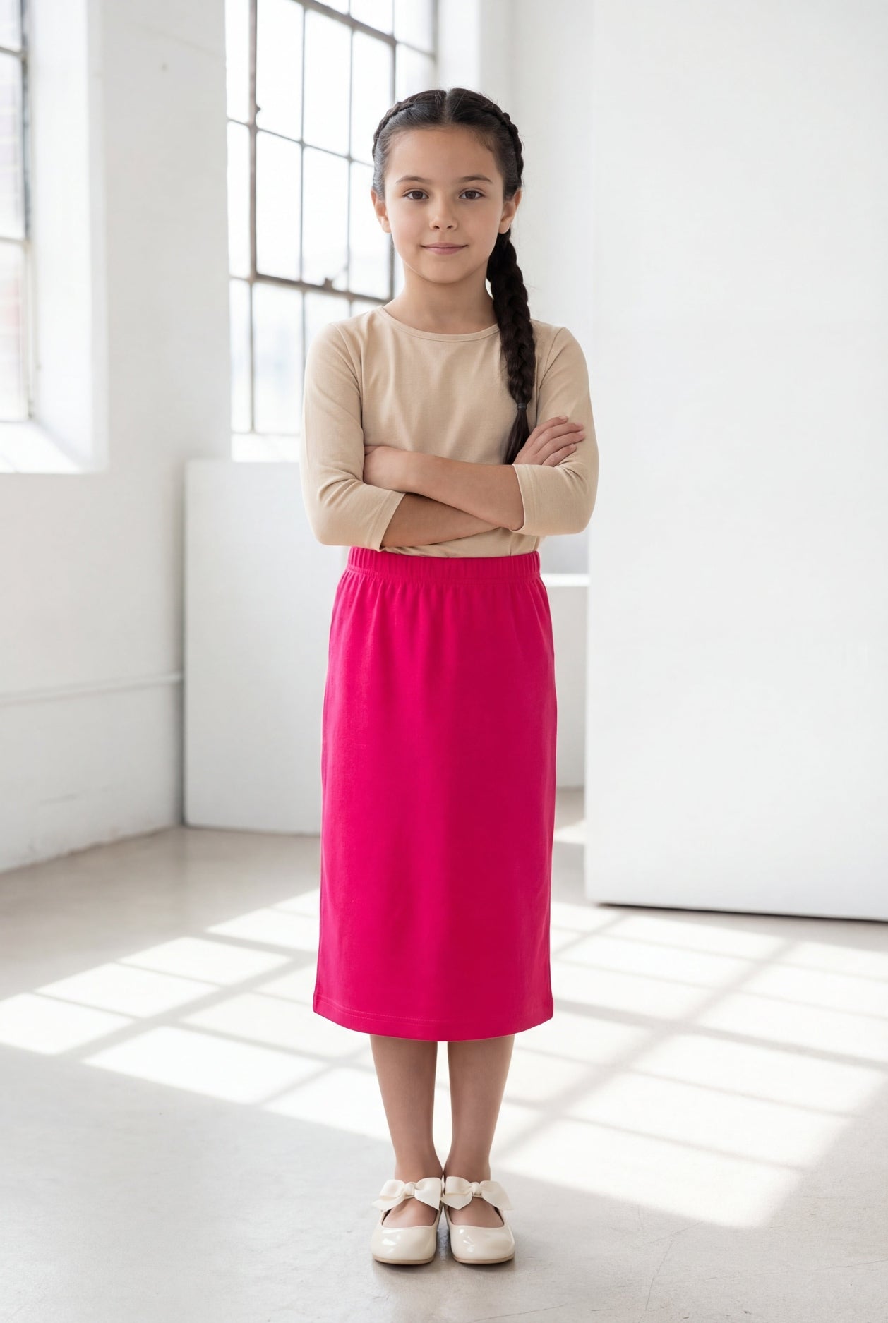 Model wearing the Nuggles® Girls' Classic Midi Skirt in Hot Pink 