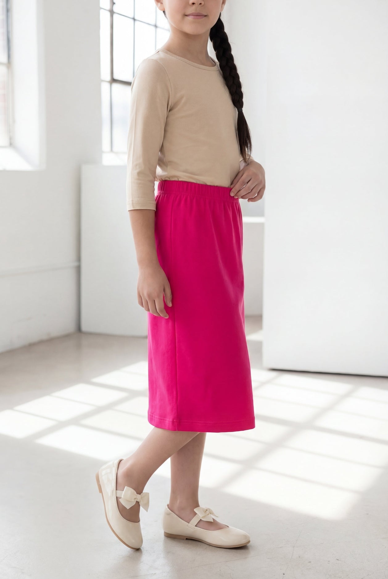 Model wearing the Nuggles® Girls' Classic Midi Skirt in Hot Pink 