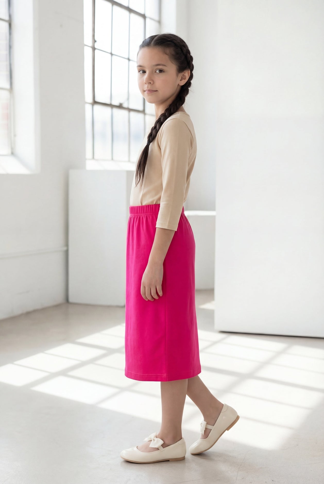Model wearing the Nuggles® Girls' Classic Midi Skirt in Hot Pink 