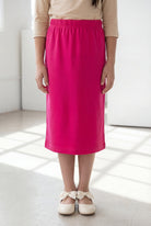 Model wearing the Nuggles® Girls' Classic Midi Skirt in Hot Pink 