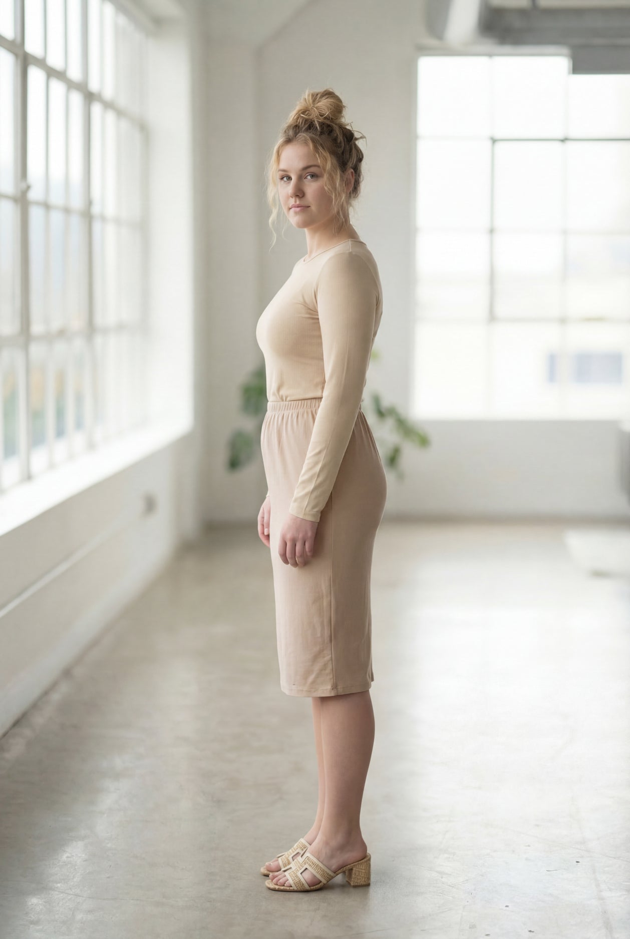 Women wearing a khaki classic 27" midi length skirt with a beige shirt in a sunlight loft.