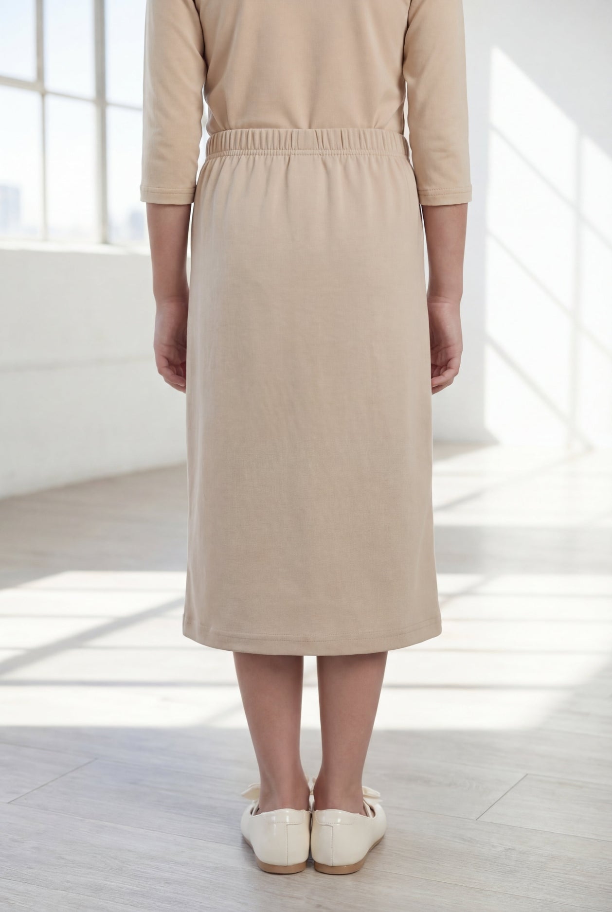 Model wearing the Nuggles® Girls' Classic Midi Skirt in Khaki