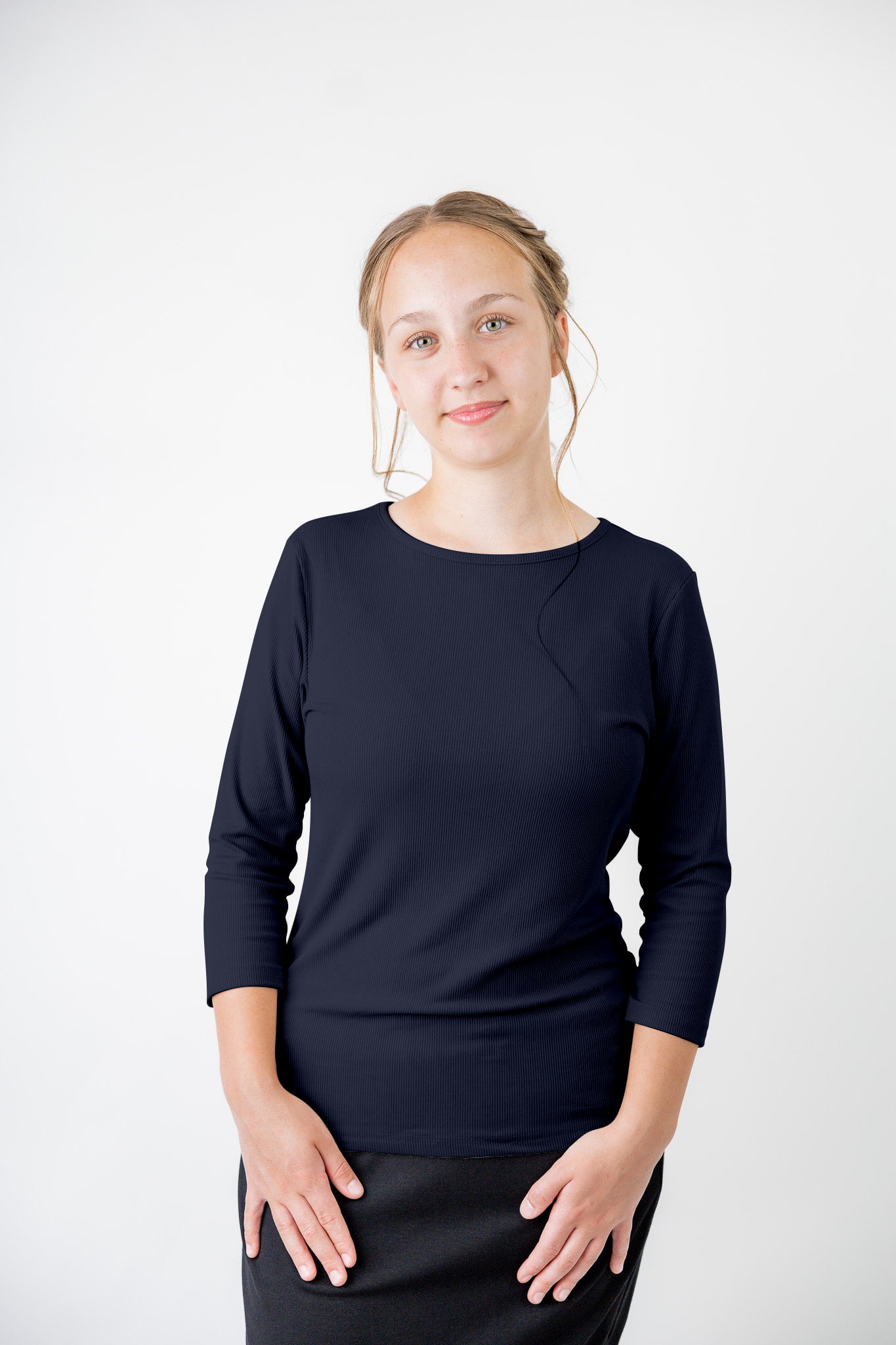 Model wearing the  Nuggles®  Essential 3/4 Tee in ribbed fabric, a modest, fitted top with 3/4 sleeves and a rounded neckline. Shown in a neutral tone, ideal for layering.