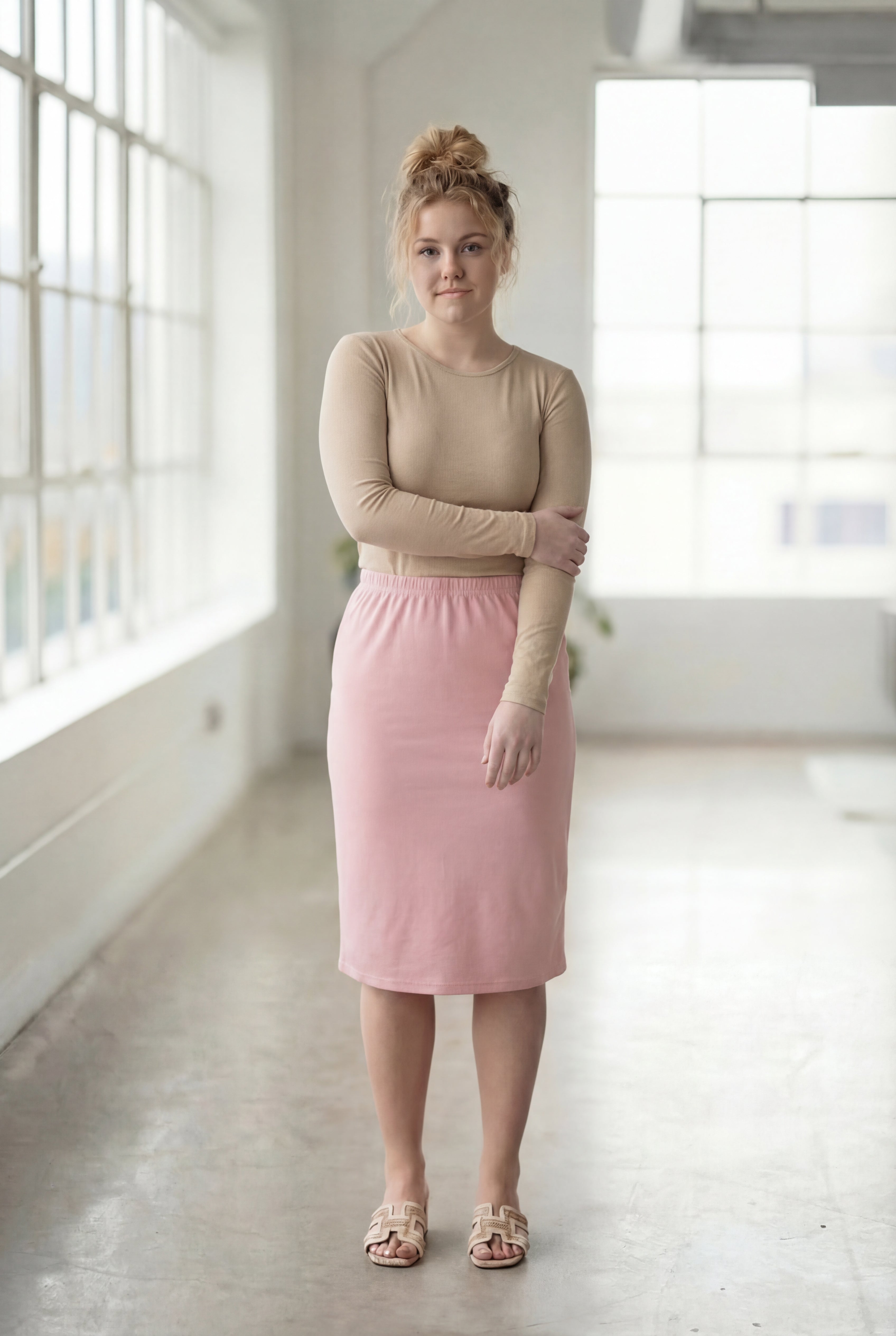 Women wearing a pink rose classic 27" midi length skirt with a beige shirt in a sunlight loft.