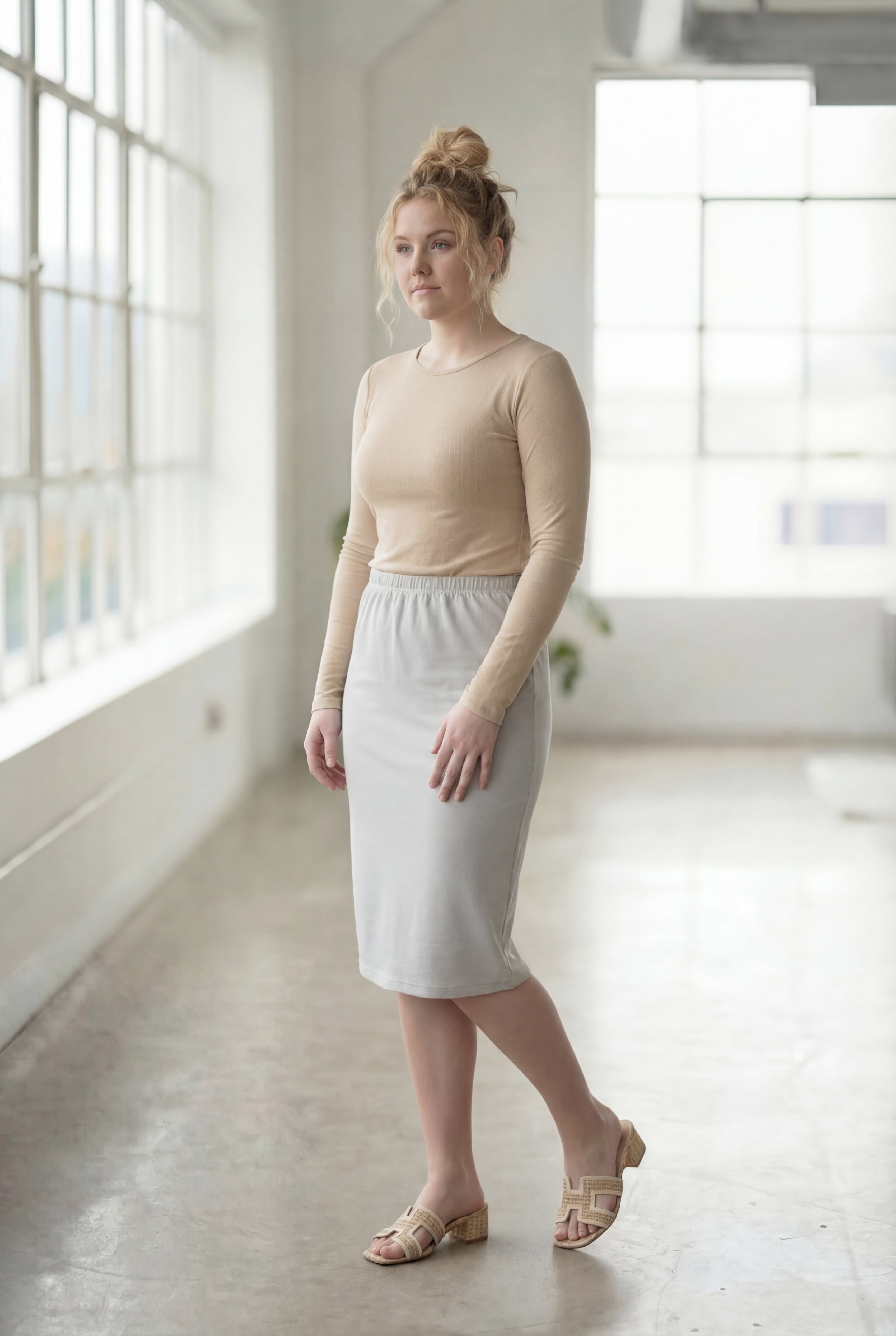 Women wearing a silver classic 27" midi length skirt with a beige shirt in a sunlight loft.