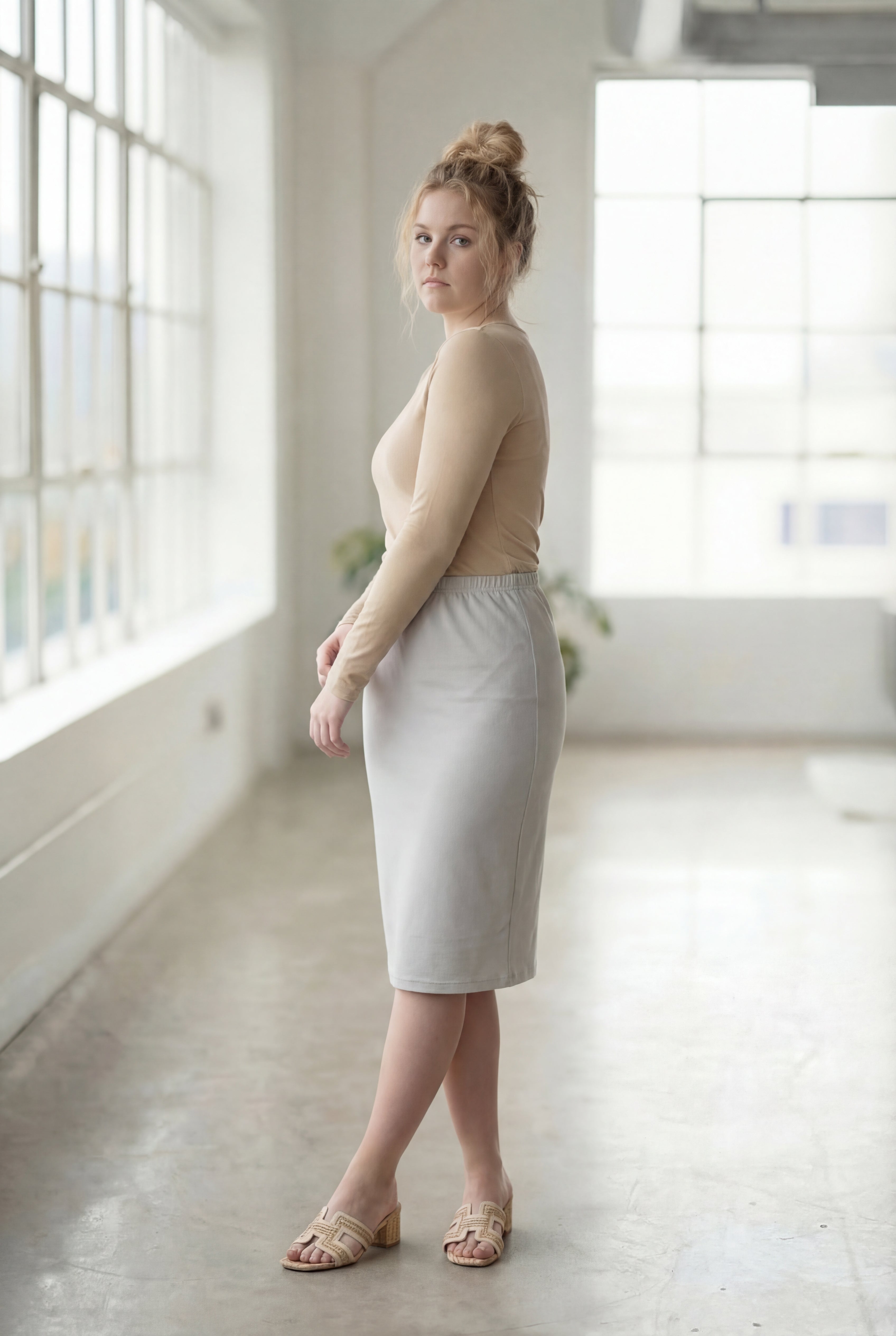 Women wearing a silver classic 27" midi length skirt with a beige shirt in a sunlight loft.