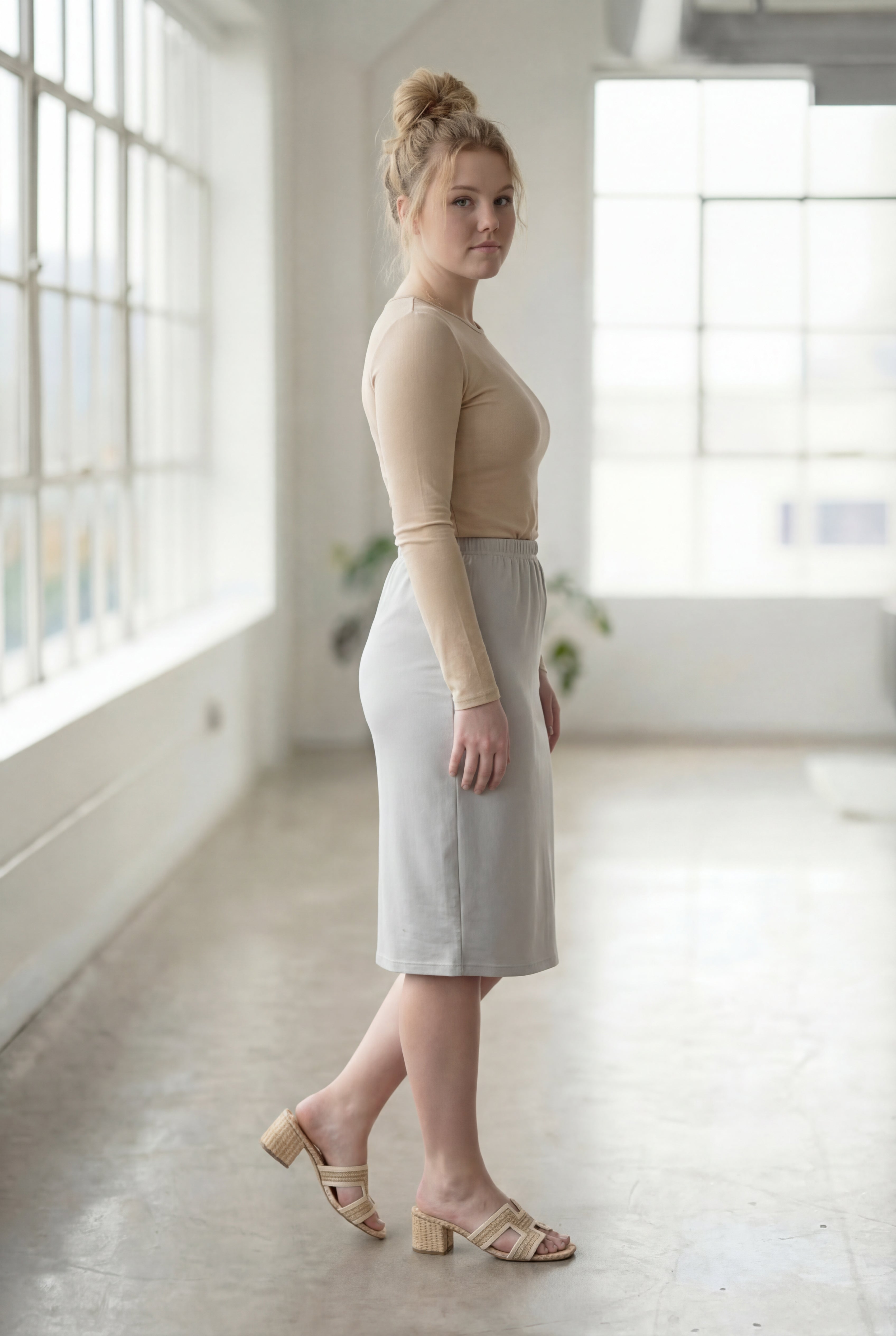 Women wearing a silver classic 27" midi length skirt with a beige shirt in a sunlight loft.