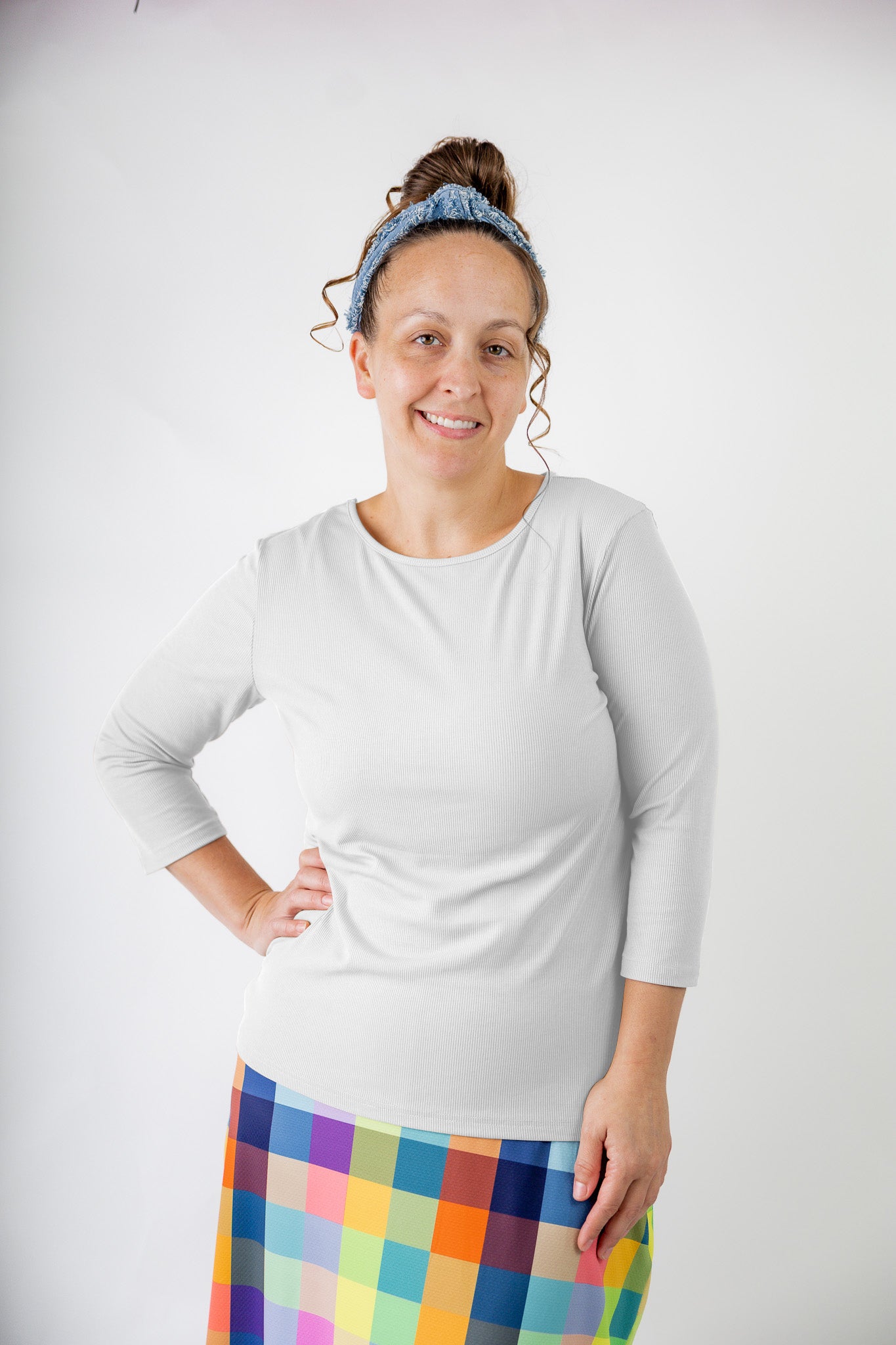Model wearing the  Nuggles®  Essential 3/4 Tee in ribbed fabric, a modest, fitted top with 3/4 sleeves and a rounded neckline. Shown in a neutral tone, ideal for layering.